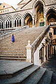 Blondes Mädchen beim Spaziergang in der Kathedrale von Amalfi. Amalfi, Amalfiküste, Provinz Sorrento, Kampanien, Italien.