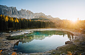 Sunset at Carezza Lake, with Latemar mountain group reflecting itself on the water. Carezza Lake, South Tyrol, Italy.