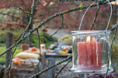 Lantern as autumn decoration in the garden in front of the seating area