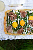 Asparagus tart with goat cheese, herbs, eggs and prosciutto