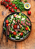 Arugula salad with green asparagus and steak strips