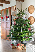 Geschmückter Weihnachtsbaum mit Geschenken im Wohnzimmer