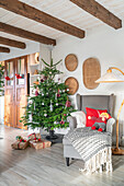 Weihnachtlich dekoriertes Wohnzimmer mit Tannenbaum und Geschenken