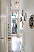 Narrow passageway with wall decoration, stained glass window in the background