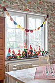 Gartenzwergsammlung auf Fensterbank im Esszimmer mit Vintage Tapete