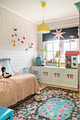 Children's room with painted sideboard under the window