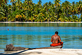 Insel Taha'a, Französisch-Polynesien. Ein einheimischer Junge spielt die Ukulele, um Ihr Mädchen auf dem Motu Mahana zu umwerben, Taha'a, Gesellschaftsinseln, Französisch-Polynesien, Südpazifik.