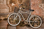 Chrome bicycle against rock wall of church in the town of Tequila, Jalisco, Mexico.