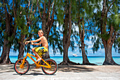 Touristischer Junge mit einem Fahrrad in Fakarava, Tuamotus-Archipel Französisch-Polynesien, Tuamotu-Inseln, Südpazifik.