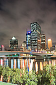 Spiegelung der bunten Lichter der Skyline des Stadtzentrums von Brisbane im Brisbane River bei Nacht, Queensland, Australien. Dieses Foto von Brisbane River und der Spiegelung der Skyline des Stadtzentrums von Brisbane bei Nacht wurde von South Bank aus aufgenommen.