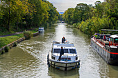 The Canal du Midi, near Carcassonne, French department of Aude, Occitanie Region, Languedoc-Rousillon France. Boats moored on the tree lined canal. The Herminis lock or Herminis ecluse.