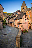 The small medieval village of Conques in France. It shows visitors its abbey-church and clustered houses topped by slate roofs. Crossing of narrow streets and monolith to the fallen ones in the war in the old medieval village of Conques on coats of the river Dordou
