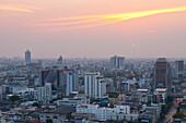 Sunset over downtown Bangkok with haze for agricultural burning; from rooftop restaurant of the Siam@Siam Hotel, Thailand.