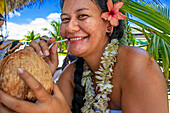 Frau trinkt Kokosnussmilch in Fakarava, Tuamotus-Archipel, Französisch-Polynesien, Tuamotu-Inseln, Südpazifik.