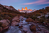 Das Fitz Roy-Massiv im ersten Licht des Sonnenaufgangs. Nationalpark Los Glaciares bei El Chalten, Argentinien. Ein UNESCO-Weltnaturerbe in der Region Patagonien in Südamerika. Der Berg Fitz Roy ist der höchste Gipfel in der Mitte. Der Bach im Vordergrund ist der Arroyo del Salto.