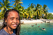 Strand von Rangiroa, Tuamotu-Inseln, Französisch-Polynesien, Südpazifik. Ein Kind spielt und springt ins Wasser.