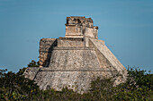 Die Pyramide des Magiers, auch bekannt als Pyramide des Zwerges. Sie ist das höchste Bauwerk in den prähispanischen Maya-Ruinen von Uxmal, Mexiko, und ragt etwa 35 Meter in die Höhe. Der Tempel am oberen Ende der Treppe links ist im Chenes-Stil gebaut, während der obere Tempel im Puuc-Stil gehalten ist.