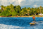Paddelsurfen am Strand von Rangiroa, Tuamotu-Inseln, Französisch-Polynesien, Südpazifik.