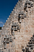 Eine Reihe von Chaac-Masken säumen die Treppe an der Westfassade der Pyramide des Magiers, die auch als Pyramide des Zwerges in den prähispanischen Maya-Ruinen von Uxmal, Mexiko, bekannt ist. Chaac ist die Regengottheit der Maya.