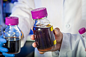 Wissenschaftlerin im Labor mit violetter Flüssigkeit