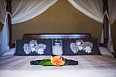 Luxury accommodation hotel bedroom details of a four poster bed and flowers laid up ready for guests to arrive, Muri, Rarotonga, Cook Islands