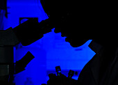 Silhouette of a person on a microscope