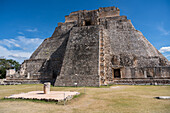 Die Westfassade der Pyramide des Magiers, die auch als Pyramide des Zwerges bekannt ist, zeigt in das Vogelviereck. Sie ist das höchste Bauwerk in den prähispanischen Maya-Ruinen von Uxmal, Mexiko, und ragt etwa 35 Meter in die Höhe. Der Tempel am oberen Ende der Treppe ist im Chenes-Stil gebaut, während der obere Tempel im Puuc-Stil gehalten ist.