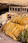 Farbenfrohe Travertinablagerungen der Mineralquelle in Puente del Inca in den argentinischen Anden mit den Ruinen eines ehemaligen Heilbads.