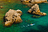 Seekajakfahren in Dubrovnik, ein Tourist beim Kajakfahren im Mittelmeer, Kroatien. Dies ist ein Foto eines Touristen beim Kajakfahren im wunderschönen türkisfarbenen Wasser des Mittelmeers in Dubrovnik.