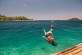 Back flip into the sea at Twin Beach, a tropical, white sandy beach near Padang in West Sumatra, Indonesia