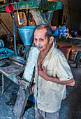 Salvadoran man work at a Corn tortilla dough factory in Suchitoto El Salvador. Corn has been a staple food in Central American cultures since pre-Columbian times