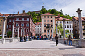 Ljubljana. People walking across the Cobblers Bridge towards Ljubljana Castle, Slovenia, Europe