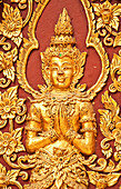 Golden Buddha figure detail on wall of Wat Mahawan Buddhist temple in Chiang Mai, Thailand.