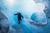 Tourist erkundet eine Eishöhle auf dem Breidamerkurjokull-Gletscher, Vatnajokull-Eiskappe, Island