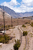Abandoned railroad tracks of the former Transandine Railway across the Andes Mountains at Puente del Inca, Argentina.