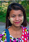 Porträt eines birmanischen Mädchens mit Thanaka im Gesicht in Mandalay, Myanmar
