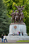 Two women taking pictures of kids at World War I memorial at state capitol, Olympia, Washington.