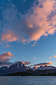 Sunrise light on the clouds over the Paine Massif in Torres del Paine National Park, a UNESCO World Biosphere Reserve in Chile in the Patagonia region of South America.