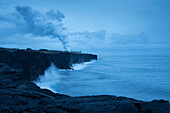Coastline and steam plume from lava entering the ocean viewed from Holei Sea Arch overlook, Hawaii Volcanoes National Park, Island of Hawaii.