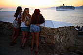 Menschen genießen die Aussicht auf Mykonos-Stadt bei Sonnenuntergang, Griechenland