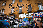 Graffiti und Schuhe, die an Drähten hängen, Metelkova City Autonomous Cultural and Social Cente, Ljubljana, Slowenien, Europa