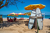 View of sunshades and surf boards on sunny morning on Kuta Beach, Kuta, Bali, Indonesia, South East Asia, Asia
