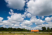 Old Orange Campervan Driving Through Heathland