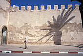 Woman And Shadow Of Palm Tree On Sidewalk