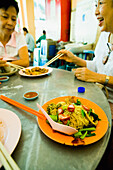 Chinese Women Eating Fried Oysters And Noodle Dishes