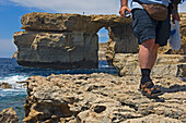 Männlicher Tourist, der auf einer Klippe in der Nähe des Azure-Fensters spazieren geht, niedriger Ausschnitt