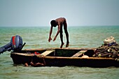 Junge taucht von Fischerboot ins Meer