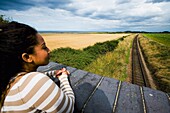 Junge Frau auf Brücke mit Blick auf Eisenbahnschienen