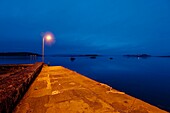 Einsame Laterne am Ufer in der Abenddämmerung