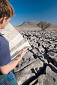Wanderer mit Karte auf Kalksteinpflaster